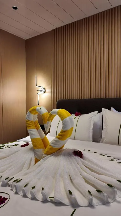 Towel swans arranged on a freshly made bed